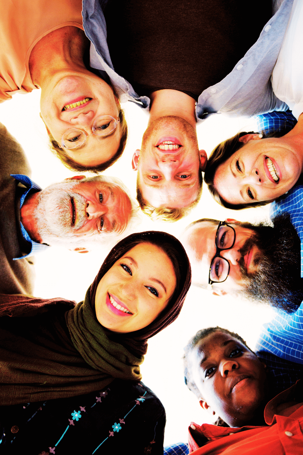 Diverse group celebrating being true to themselves, indoors with bright, inviting lighting.