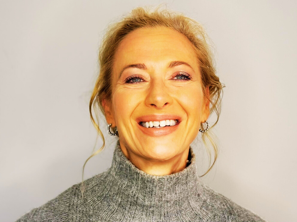 Dr. Madisen Harper smiles joyfully, with striking eyes and cozy sweater, exuding warmth and positivity.